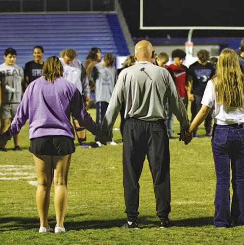 Students from Lampasas and Lometa gather on Badger Field to pray at the conclusion of the Fields of Faith event Wednesday night. The local chapter of Fellowship of Christian Athletes hosts the annual night of student-led prayer and fellowship. HUNTER KING | DISPATCH RECORD