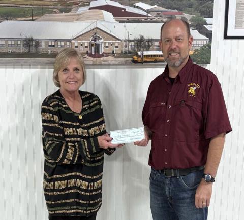District Clerk Edith Wagner Harrison presents Lometa ISD Superintendent Rob Moore with a check for $19,161. The funds will assist the school district with furnishing supplies for the new automotive program. COURTESY PHOTO