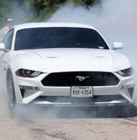 A white Ford Mustang burns out during Saturday’s event. CHRIS MILES | DISPATCH RECORD