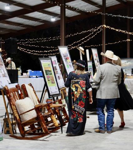 Boots and Blazers Ball attendees scope out items available for auction in last year’s event. FILE PHOTO