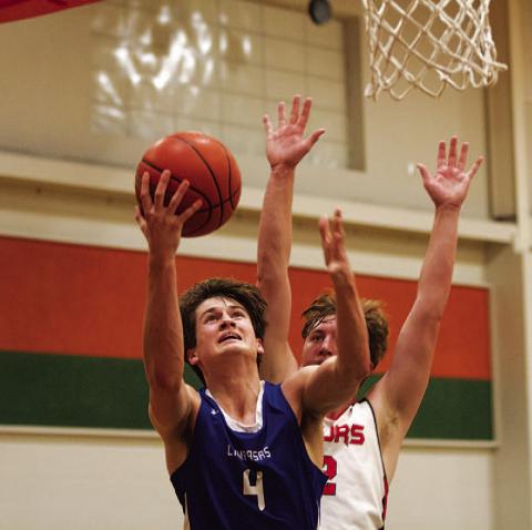 HUNTER KING | DISPATCH RECORD Calum Mitchell jumps toward the basket during the district finale.