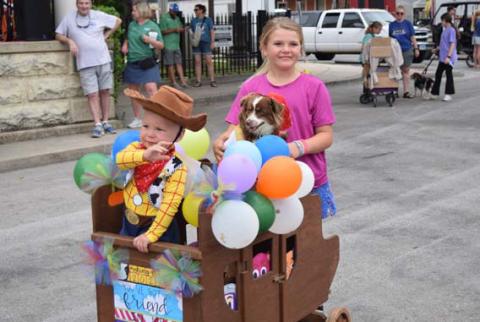 Tye Langford, right, leads Eli Joseph Straley, left, and puppy pal Lori Darlin’, center, in a “Toy Story”-themed parade display on Friday morning. The three won Pet Parade Grand Champion honors for Tate Langford, not pictured. ALEXANDRIA RANDOLPH | DISPATCH RECORD