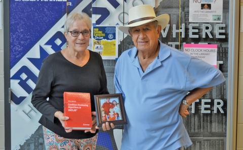 erick mitchell | dispatch record Sherry and Bob Ellis hold a photo of Adam Jablonski’s family and the former LHS exchange student’s published textbook. Jablonski is a university professor now in Poland.