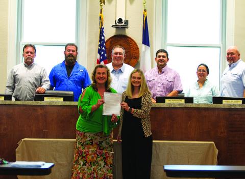 Becky Sims, left, and Kayleigh Stanley pose with the city council after being recognized for Professional Municipal Clerks Week at Monday’s meeting. HUNTER KING | DISPATCH RECORD