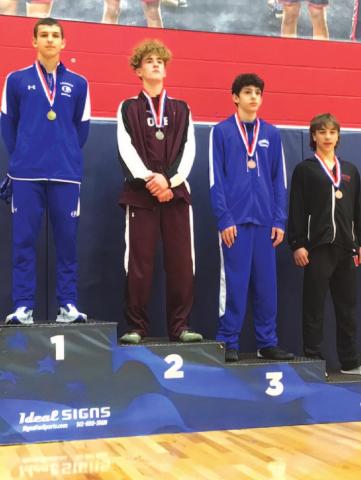 Rylan Myers, left, stands on top of the podium after finishing first during the district wrestling meet last week. COURTESY PHOTO