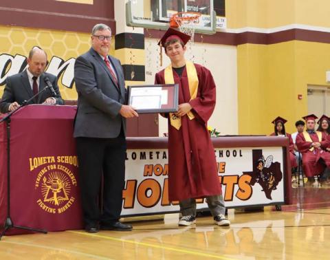 MASON HINES | DISPATCH RECORD Principal Ken Frazier, left, presents Class of 2025 valedictorian Diego Garrido with his award certificate and medal as the top-ranking graduate at Lometa High School.