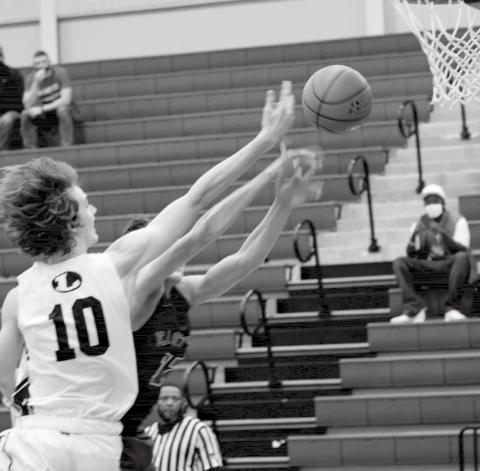 Kaeden Crawford fights for control of the ball at the boards. Crawford led the Badgers’ scoring Tuesday with 17 points against the Austin Achieve Polar Bears. JEFF LOWE | DISPATCH RECORD