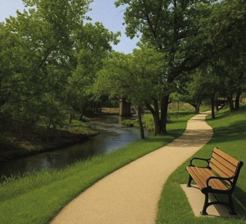 This artificial intelligence-generated photo offers an idea of what a walkway could look like along the meandering Sulphur Creek if the area near the Fourth Street bridge is cleared of invasive brush and maintained. See page 8 for a photo of the creekbank as it looks currently. COURTESY ILLUSTRATION | SHAWN KIRKPATRICK