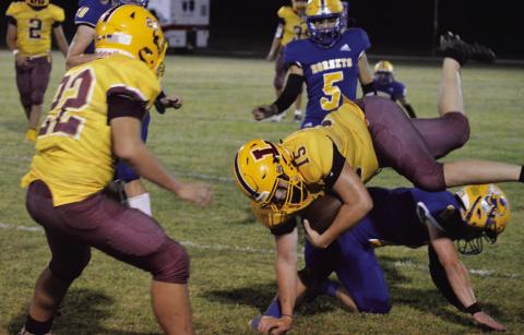 Jacob Wooten (15) gets upended after catching a pass. MASON HINES | DISPATCH RECORD