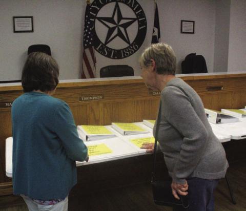 Lometa resident Cynthia Kirby, left, and Lometa City Council member Gloria Martin review the city’s breakdown of accounts on display at Monday night’s council meeting. CHERI JAY-WIENECKE | DISPATCH RECORD