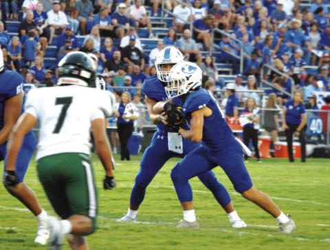David Flores reads the Connally defensive end before handing the ball to Ethan Moreno. HUNTER KING | DISPATCH RECORD