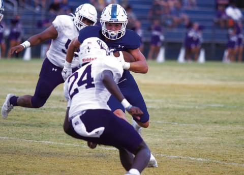 Jett Walker stares down an Elgin defender as he runs toward the end zone. HUNTER KING | DISPATCH RECORD