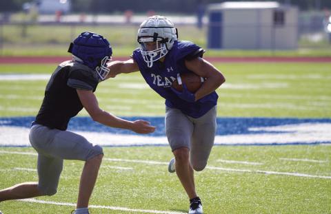 Haegan Oncken throws a stiff arm trying to make a defender miss during Saturday’s scrimmage. HUNTER KING | DISPATCH RECORD