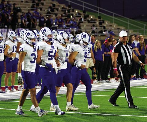  The football team’s captains walk onto the field for the opening coin toss.