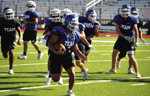 HUNTER KING | DISPATCH RECORD Dailin Fagan looks up field for defenders during a practice last week. He will take his varsity carry tonight in Elgin.