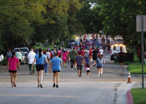  Runners and walkers head down the road during the race.
