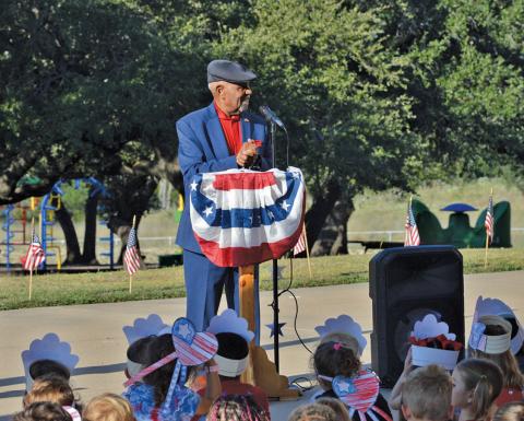 The retired Air Force Chief Master Sgt. Sherman Harper Jr. addresses Taylor Creek Elementary School students on the 24th anniversary of the Sept. 11 terrorist attacks. He also explained the meaning of the colors used in the U.S. flag and encouraged students to honor and respect it. erick mitchell | dispatch record