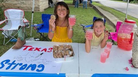 Lucy and Aspyn Shelton offered homemade cookies and lemonade to Spring Ho parade attendees last week in exchange for donations that will be forwarded to a Hill Country family who has suffered loss due to the July 4 flooding in Central Texas. courtesy photo