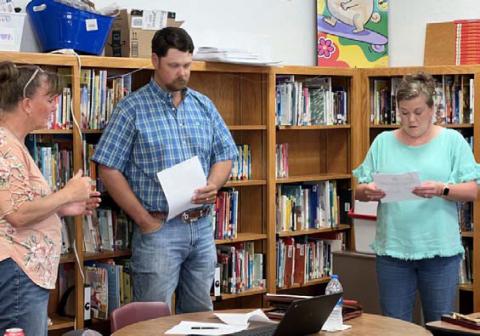Lometa ISD Business Manager Ronda Bridges, left, administers the oath of office to school board trustees Dusty Duncan and Cristopher Brister. MASON HINES | DISPATCH RECORD