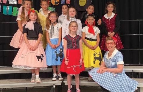 The Jingle Bell Jukebox Drama Club is pictured here: front row, student Madelynn Scott and teacher Linda Lapierre (seated); middle row from left, Madison Orr, Kaylee Berg, Madison Martin and Zoey Rivas; back row, Gabby Schlipp, Hadley Perry, Emma Miller, John Lake and Ava Ramirez. COURTESY PHOTO