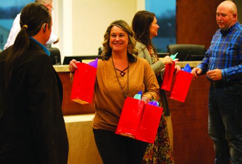 City Secretary Becky Sims, center, and City Manager Erin Corbell distribute gift bags to council members Zachary Morris, left, and Davis Keele. The bags contain a commemorative coin given to each member annually in appreciation for their service rendered to the city. HUNTER KING | DISPATCH RECORD