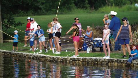 HUNTER KING | DISPATCH RECORD Kids lined the creek in W.M. Brook Park last Wednesday morning for the annual Kiddie Fishing Derby.
