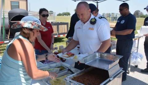 Air Evac member Tawyla Bomar serves Killeen Fire Department Battalion Chief Justin Kemp at last week’s first responder cookout during National EMS Week. MASON HINES | DISPATCH RECORD