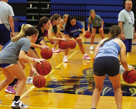 Campers focus on the power dribble in the high school gym. HUNTER KING | DISPATCH RECORD