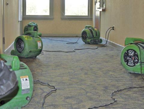 ServPro representatives assisted with water removal in the county annex offices and set up fans to help dry the areas flooded over the weekend by a malfunctioning drinking fountain. erick mitchell | dispatch record