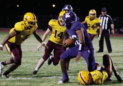 Jordan Livesay (3) wrangles an Eden ball carrier, while Elijah Gonzales (5) and Colton Whitehead (14) pursue. MASON HINES | DISPATCH RECORD
