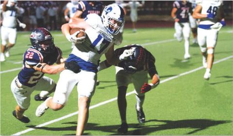 Preston Isom fights through two Wimberley tacklers on his way to the end zone last Friday night. HUNTER KING | DISPATCH RECORD