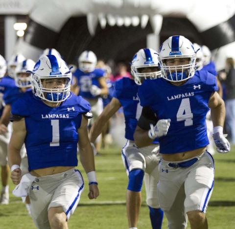 Luke Smith, left, and Aden Rascoe take the field out of the tunnel before the game against Burnet last week. HUNTER KING | DISPATCH RECORD