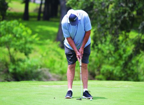 HUNTER KING | DISPATCH RECORD Ron Acker hits a short par putt during day two of the tournament on Sunday.