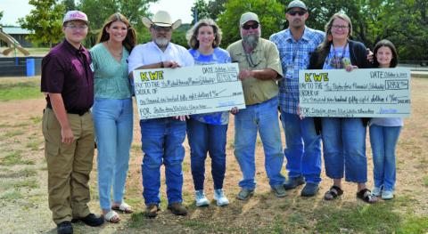 Kline Whitis Elementary School students raised more than $3,900 for the Peyton Jones Memorial Scholarship and the Michael January Memorial Scholarship. Pictured at left are second-grade teacher Amy Brown and her family, representing the January scholarship, and Shante Seward, second from right, with her family, representing the Jones scholarship. ERICK MITCHELL | DISPATCH RECORD