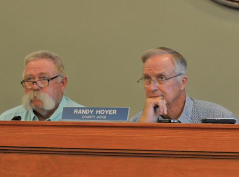 Precinct 3 Commissioner Lewis Bridges, at left, and County Judge Randy Hoyer listen to a presentation on the tax rate at Monday’s Commissioners Court meeting. erick mitchell | dispatch record