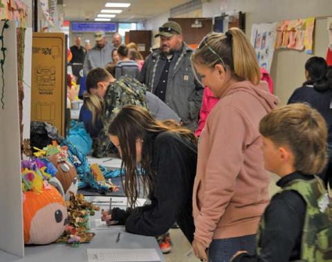 Student-decorated pumpkins line the hallway during Monday night’s Fall Fest at Kline Whitis Elementary. The PTA sponsored a contest, with Police Chief Jody Cummings and Fire Chief Jeff Smith serving as judges. Pumpkins were auctioned afterward. erick mitchell | dispatch record