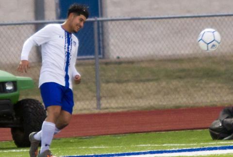 Victor Castruita kicks the ball near the sideline before going on to score one of the varsity’s early goals against the alumni on Tuesday. JEFF LOWE | DISPATCH RECORD