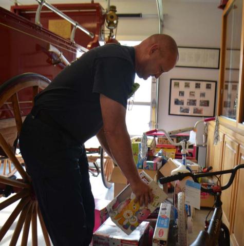 Lampasas firefighter Sean Schroeder sorts toys inside the fire station on Friday. Distribution to families that have applied will take place Dec. 18. Kempner residents may sign up for toys at the fire station there. Families in Lometa who would like to receive gifts should contact Lometa City Hall to participate in the toy drive. In Adamsville, area churches can assist families in need. MONIQUE BRAND | DISPATCH RECORD