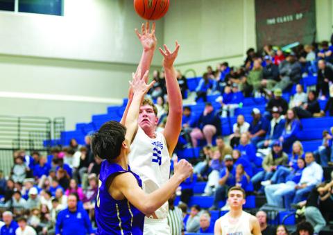 HUNTER KING | DISPATCH RECORD Beau Patterson shoots over an outstretched hand as the crowd watches behind him.