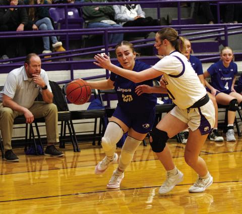 Payton Crawford dribbles baseline against Marble Falls as players on the bench look on. HUNTER KING | DISPATCH RECORD