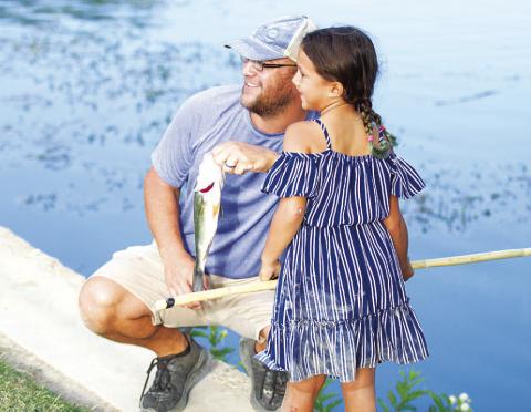 Jillian Rincones and her dad Nathan Rincones pose with her 13-inch bass at the fishing derby. HUNTER KING | DISPATCH RECORD