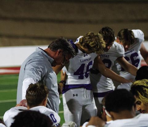 HUNTER KING | DISPATCH RECORD Head coach Troy Rogers bows his head to pray with his team after last Friday’s playoff game.