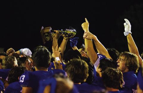 The Badger football team raises their new golden football after winning over Pecos last Thursday night. HUNTER KING | DISPATCH RECORD