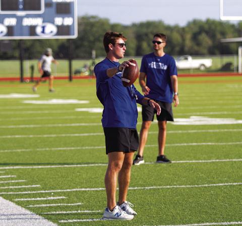 Assistant football coach Hadley Berry works with receivers at football camp. HUNTER KING | DISPATCH RECORD