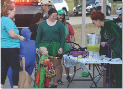 At right, Kempner City Manager Rebecca Ramos helps a trunk-or-treater to a cup of punch during last year’s event. This year’s event will take place at the Sylvia Tucker Memorial Park. courtesy photo | Johnny Anderson