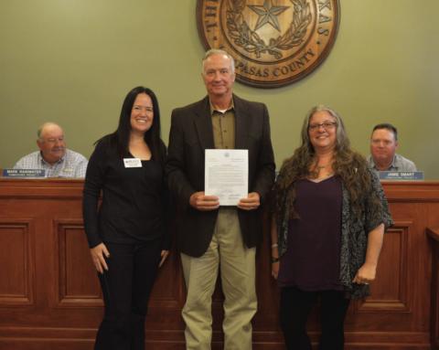Lampasas County Judge Randy Hoyer (center) holds the proclamation that declared Thursday as Go Purple Day in Lampasas County. He is joined by Kaylene Vaughn (left) and Amber Balusek of the Highland Lakes Family Crisis Center. ERICK MITCHELL | DISPATCH RECORD