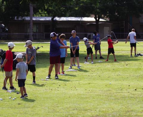 Young golfers work on their short shots during golf camp last Tuesday. HUNTER KING | DISPATCH RECORD