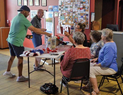 erick mitchell | dispatch record Putters &amp; Gutters guests make donations to the American Legion Auxiliary in honor of National Poppy Day, which was recognized last Friday. Auxiliary volunteers were at the local business to hand out red poppies in memory of America’s fallen heroes.