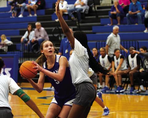 HUNTER KING | DISPATCH RECORD Lainey Dixon looks to shoot over a defender for Manor New Tech during the Lady Badgers’ first scrimmage on Tuesday.