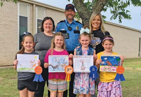 Front row, left to right, are Kylee Kruppa, Ava Latham, Kylee Davis and Evie de Klerk. These students were recognized by the Texas Department of Health and Human Services for their artwork in the department’s Rabies Awareness and Prevention Poster Contest. Back row are Kasey Schwartzer, supervisor of the local animal shelter; animal control officer Joseph Schwartzer; and Kline Whitis Principal Leanne Bobo. erick mitchell | dispatch record
